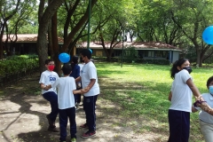 Jugando y aprendiendo: Los estudiantes responden preguntas mientras mantienen un globo en el aire.